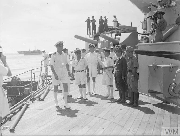 PENANG CONFERENCE ON BOARD HMS NELSON. 28 AUGUST TO 2 SEPTEMBER 1945, ON BOARD THE BRITISH BATTLESHIP HMS NELSON, FLAGSHIP OF VICE ADMIRAL H T C WALKER. DURING THE PENANG SURRENDER AND RE-OCCUPATION NEGOTIATIONS. REAR ADMIRAL UZUNI AND THE JAPANESE GOVERNOR OF PENANG SIGNED FOR THE JAPANESE AFTER WHICH THE DOCUMENTS OF AGREEMENT WERE SIGNED BY VICE ADMIRAL H T C WALKER AT 2115 HOURS ON 1 SEPTEMBER 1945. ROYAL MARINES OF THE BRITISH EAST INDIES FLEET FORMALLY TOOK OVER THE ISLAND ON 3 SEPTEMBER 1945. (A 30472) The Japanese officers arrive on board the NELSON, one is carrying a chart and in the centre is Captain Hidaka, Senior Japanese Naval Officer at Penang. Copyright: © IWM. Original Source: http://www.iwm.org.uk/collections/item/object/205161601